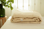 Lightweight wool comforter in beige bedroom — breathable bedding